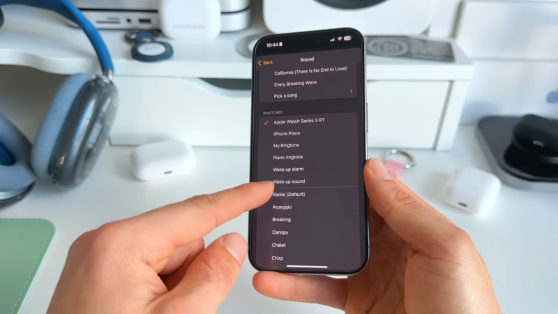 Person Selecting a Song and Ringtone Options on An iPhone's Alarm Settings Screen