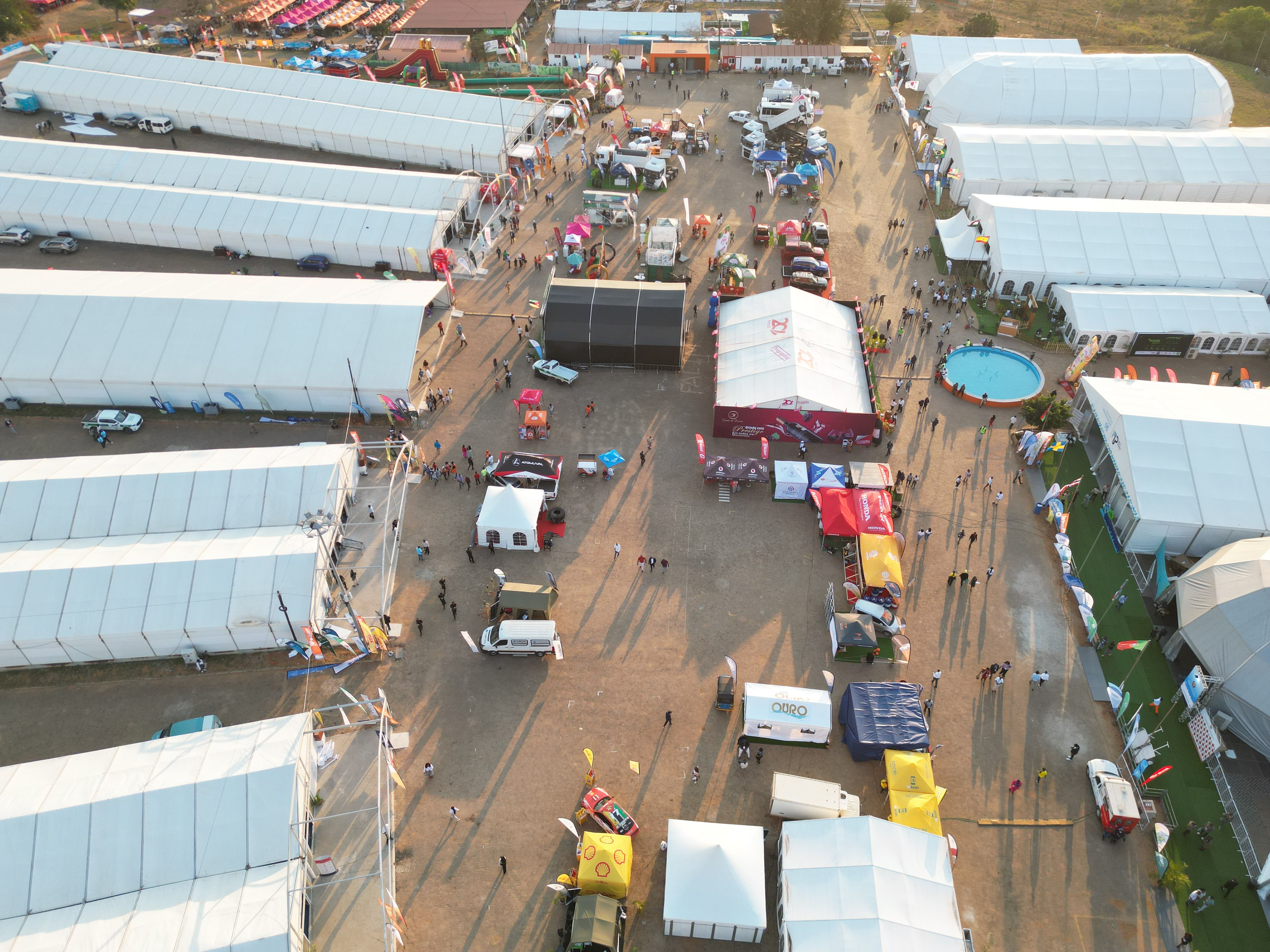 Aerial view of an outdoor event with organized tents and circulation areas, useful for illustrating festival site planning.