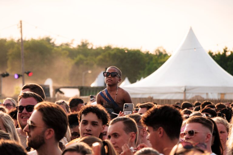 Outdoor music festival crowd gathered among tents at sunset, illustrating an inviting and well-planned event space.